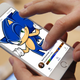 A mobile device screen displays a composite image of the GETTR social app and a smirking, shrugging Sonic the Hedgehog.